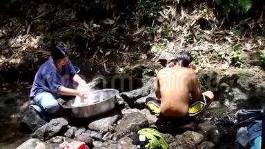 菲律宾农村社区缺乏公共供水系统设施，迫使这名妇女即使在污染的河流中也要洗衣服。