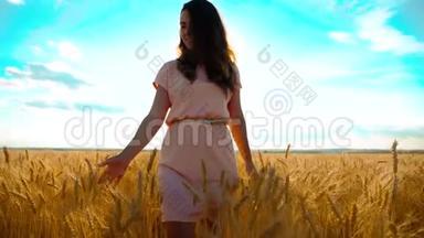 女孩正沿着麦田走大自然慢动作视频.. 美丽的女孩穿着白色的裙子奔跑着大自然的自由