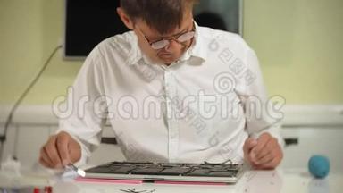 一个人正在修理笔记本电脑。 计算机修复的概念.. 用一个人修理笔记本电脑主板
