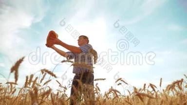 老农夫<strong>剪影</strong>面包师拿着一个<strong>金色</strong>的面包和面包在成熟的小麦生活方式领域对抗蓝天。 慢慢慢慢