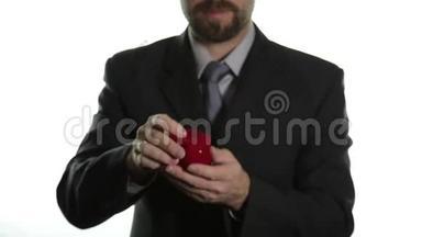 穿着商务服<strong>的大胡子男人</strong>在红盒子里戴上戒指，表达不同<strong>的</strong>情感