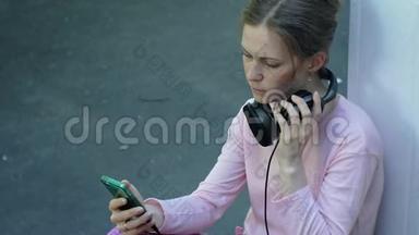 年轻时尚的美女，在城市街道上听音乐的大监控耳机。