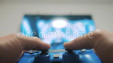 在电视上播放视频控制台。 手握新的操纵杆在电视上播放视频控制台。 玩家用游戏本玩生活方式游戏
