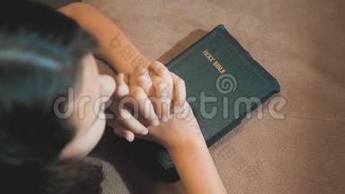 小女孩在夜里祈祷。 小女孩用手祈祷。 小女孩圣经祈祷与圣经在她的手中。 (a)