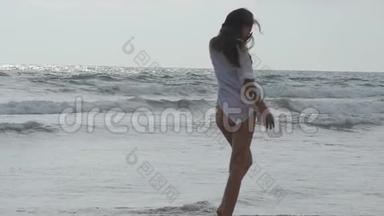 女人在海边散步玩耍。 年轻漂亮的女孩在岸上享受生活。 暑假或
