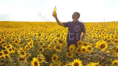 农夫用向日葵在田野里探索。 慢动作生活方式视频。 男人的生活方式农民手拿瓶子