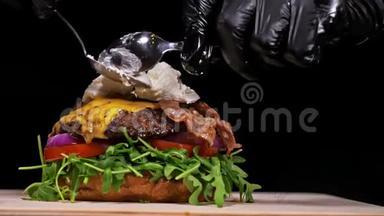汉堡在<strong>黑色</strong>背景下用<strong>黑色</strong>食物手套做饭。 非常<strong>美味</strong>的空气面包和大理石牛肉。 餐厅