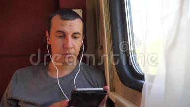 男子在火车上听音乐，<strong>火车车厢</strong>轿跑车旅行。慢动作视频。生活方式a的男人