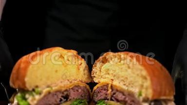汉堡在<strong>黑色</strong>背景下用<strong>黑色</strong>食物<strong>手套</strong>做饭。 非常美味的空气面包和大理石牛肉。 餐厅