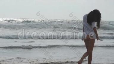 年轻漂亮的女孩在海边享受生活和乐趣。快乐的女人在海边散步。夏天