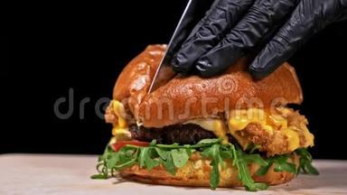 汉堡在黑色背景下用黑色食物手套做饭。 非常美味的空气面包和大理石牛肉。 餐厅
