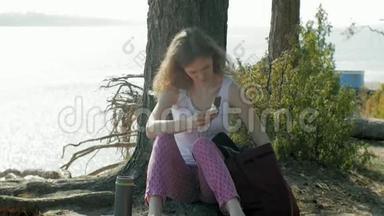 在森林里<strong>喝热水</strong>瓶里的茶的年轻女子