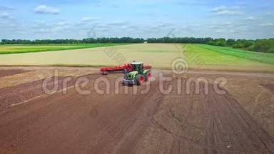 农业拖拉机，拖车在农村耕地上耕作。 农业产业