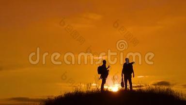 两个男子游客徒步旅行生活剪影去山上日落旅行慢动作视频。 旅行者成功