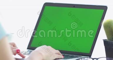 女士使用笔记本<strong>电脑</strong>与关键的绿色屏幕。