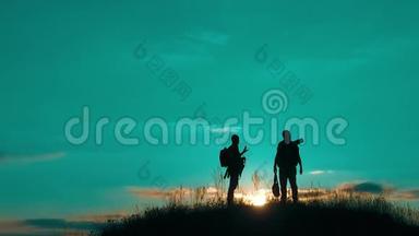 两名男子游客徒步旅行者剪影生活方式去山上日落旅游慢动作视频。 旅行者成功