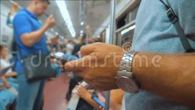 休闲男子从手机智能手机屏幕上阅读，同时看导航员在地铁上旅行的生活方式