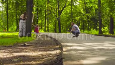 快乐的父母和小女孩在公园散步