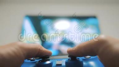 在电视上播放视频控制台。 手握新的操纵杆在电视上播放视频控制台。 玩家玩游戏游戏与游戏本