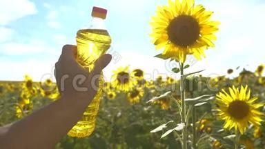 农夫手里拿着一瓶塑料生活方式的葵花籽油，在他的手里的阳光下。 慢动作视频。 农业