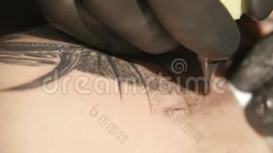纹身艺术家在工作室做纹身，纹身在身体上。 近点