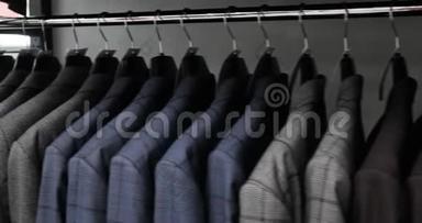 一排男人在衣架上穿夹克。商店里挂在衣架上的新漂亮衣服