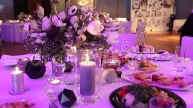 餐桌上的装饰蜡烛，桌子上的眼镜和圣诞蜡烛，带玻璃的白色蜡烛