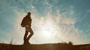 旅游旅行者徒步旅行者的剪影。 男人带背包，男人在日落时的剪影生活方式，户外男人是