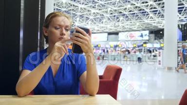 女士在机场候机室使用智能手机。 对机场飞行的期望。 4k，慢动作