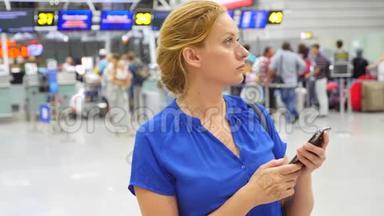 女士在机场候机室使用智能手机。 对机场飞行的期望。 4k，慢动作