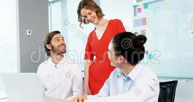微笑的商务同事在<strong>会议室讨论</strong>笔记本电脑