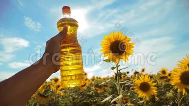农夫手里拿着一瓶塑料葵花籽油，阳光洒在他的手里。 慢动作视频。 蓝天背景