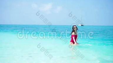 海滩上的年轻美女。 快乐的女孩享受热带度假的异国风情岛