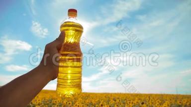 慢动作录像。 日落时分，农夫手捧一瓶葵花籽油. 。 农民农业塑料