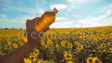 农夫用向日葵在田野里探索。 农夫手里拿着一瓶塑料<strong>葵花籽</strong>油