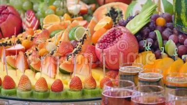 不同的新鲜水果在婚礼自助餐桌上。 水果和浆果婚礼桌装饰。 自助接待水果