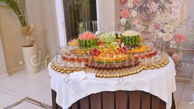 不同的新鲜水果在婚礼自助餐桌上。 水果和浆果婚礼桌装饰。 自助接待水果