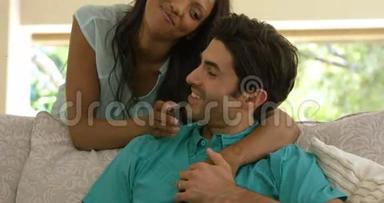 快乐的年轻夫妇在沙发上互<strong>相拥</strong>抱