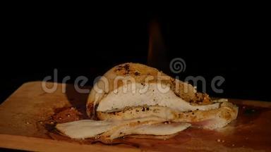 鸡片放在火木板上.. 烤肉。 深色背景