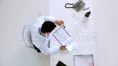 医生在诊所用剪贴板记录心电图