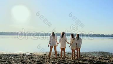 黎明时分，四个女孩在湖边沙滩上跳舞