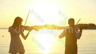 小提琴二重奏在湖上日落时分，男人和女人在大自然中拉小提琴