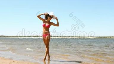 海滩上摆姿势的晒黑的年轻女子