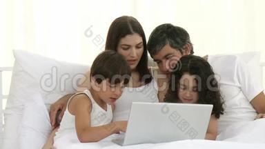 <strong>家长</strong>和儿童在床上使用笔记本电脑