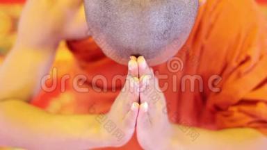 僧人身穿橘色长袍，在寺庙内祈祷
