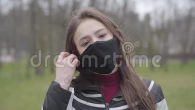 黑发女孩摘下防护面具和触<strong>摸脸</strong>的肖像。 年轻白种人无视冠状病毒