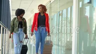 两位非裔美国女孩的旅行者<strong>正在</strong>搬运行李，并在候机楼的休息室里走动。 人们<strong>正在准备</strong>