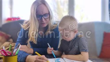 学龄前儿童从事家庭教育。 这个男孩坐在一张桌子旁，在网上写作、画画和学习。 检疫到期
