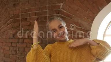微笑的女孩少年用手在红砖<strong>背景</strong>前相机上跳舞。 快乐的年轻女子表演<strong>舞蹈</strong>