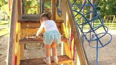 快乐的童年概念。 孩子爬上楼梯，`孩子们<strong>滑倒</strong>。 妈妈和宝宝在操场上玩。 开心快乐